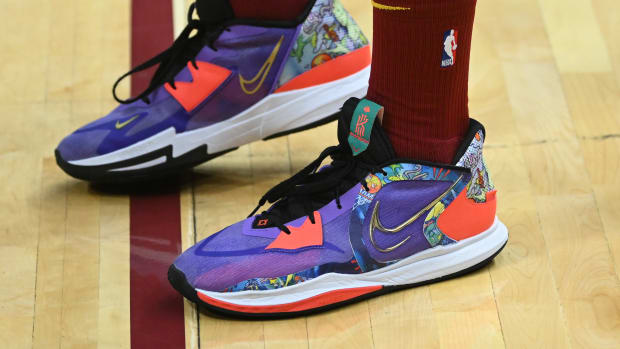View of purple and orange Nike Kyrie shoes.